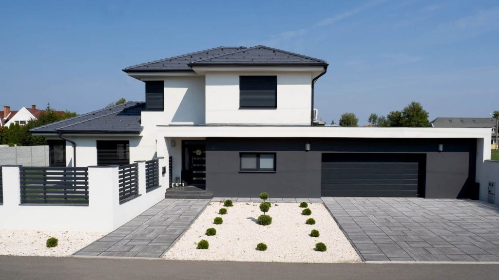 Terrán Zenit Max Grafit sötétszürke tetőcserép SW Zselickő Grafit típusú térkővel kombinálva. Térkővel és fehér kaviccsal burkolt kocsibeállóval. Terrán Zenit Max Grafit sötétszürke tetőcserép SW Zselickő Grafit típusú térkővel kombinálva.