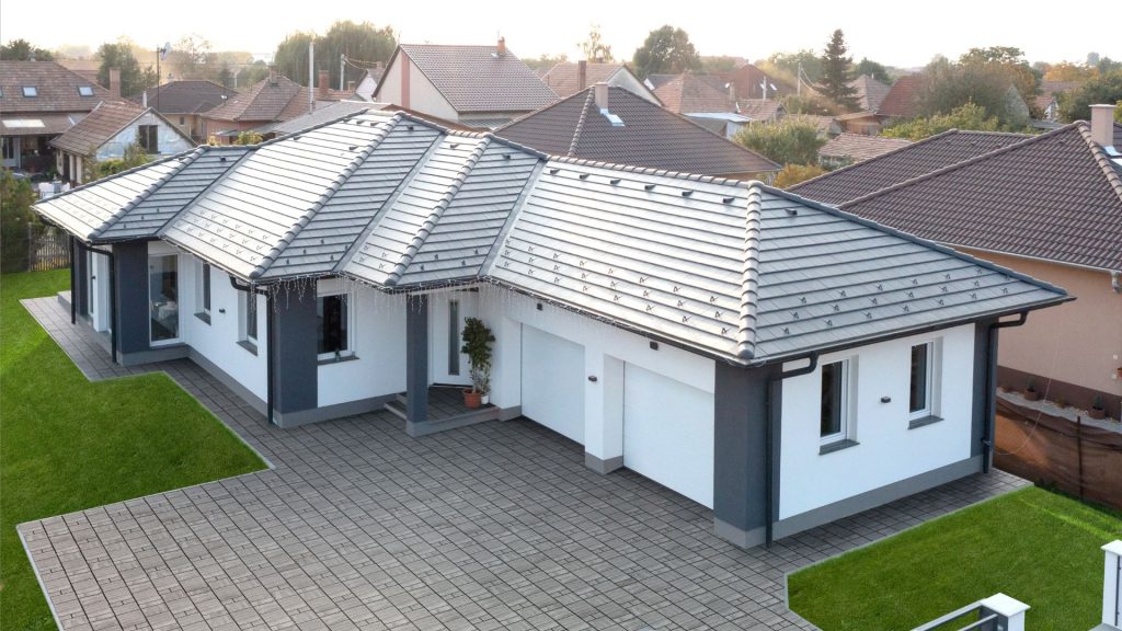 Terrán Zenit Max Gránit szürke tetőcserép SW Írottkő Agyag típusú térkővel kombinálva. a ház körül zöld gyep élénkíti az összképet. Terrán Zenit Max Gránit szürke tetőcserép SW Írottkő Agyag típusú térkővel kombinálva.